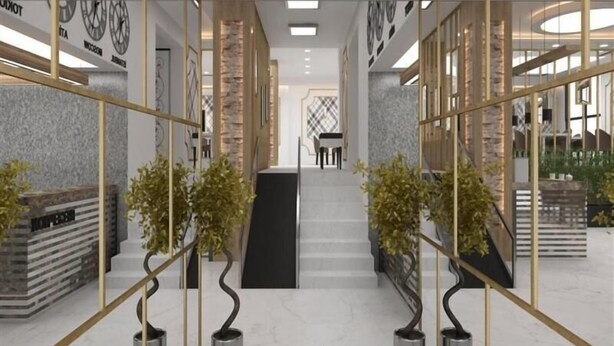 Un interior moderno con una escalera central, divisiones de vidrio y una zona de recepción.