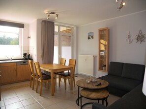 A compact living space with a dining area, kitchen, and seating area.