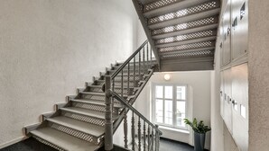 A staircase with a wooden handrail and a carpeted landing.