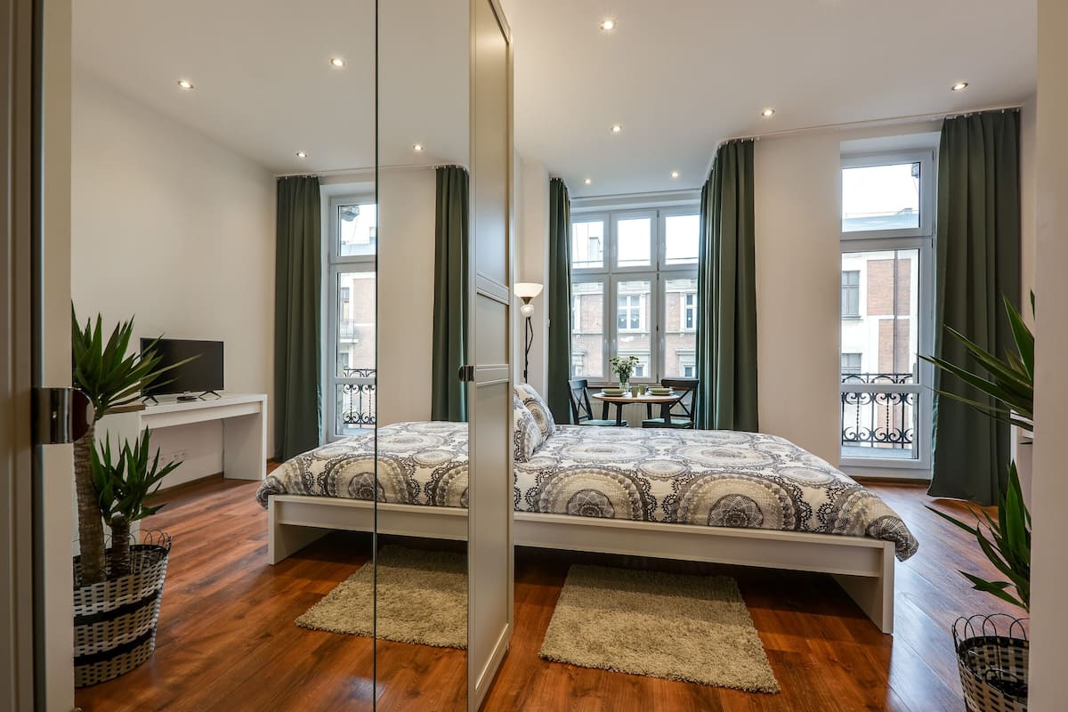 Un dormitorio moderno con una cama grande, un escritorio y un balcón con vistas.
