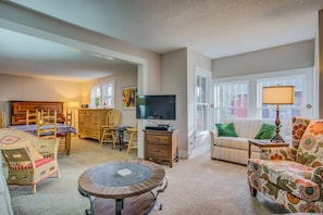 A living room with a piano, television, and a patterned armchair. - 5brmonument Historic Charmminutes To Hiking (Monument)