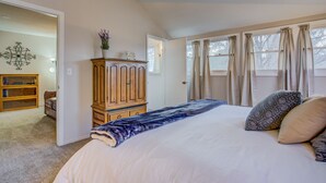 A bedroom with a large bed, a wooden wardrobe, a bookshelf, and a decorative wall piece. - 5brmonument Historic Charmminutes To Hiking (Monument)