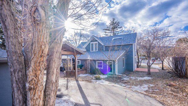 A residential house with a covered porch, a garage, and a driveway. - 5brmonument Historic Charmminutes To Hiking (Monument)
