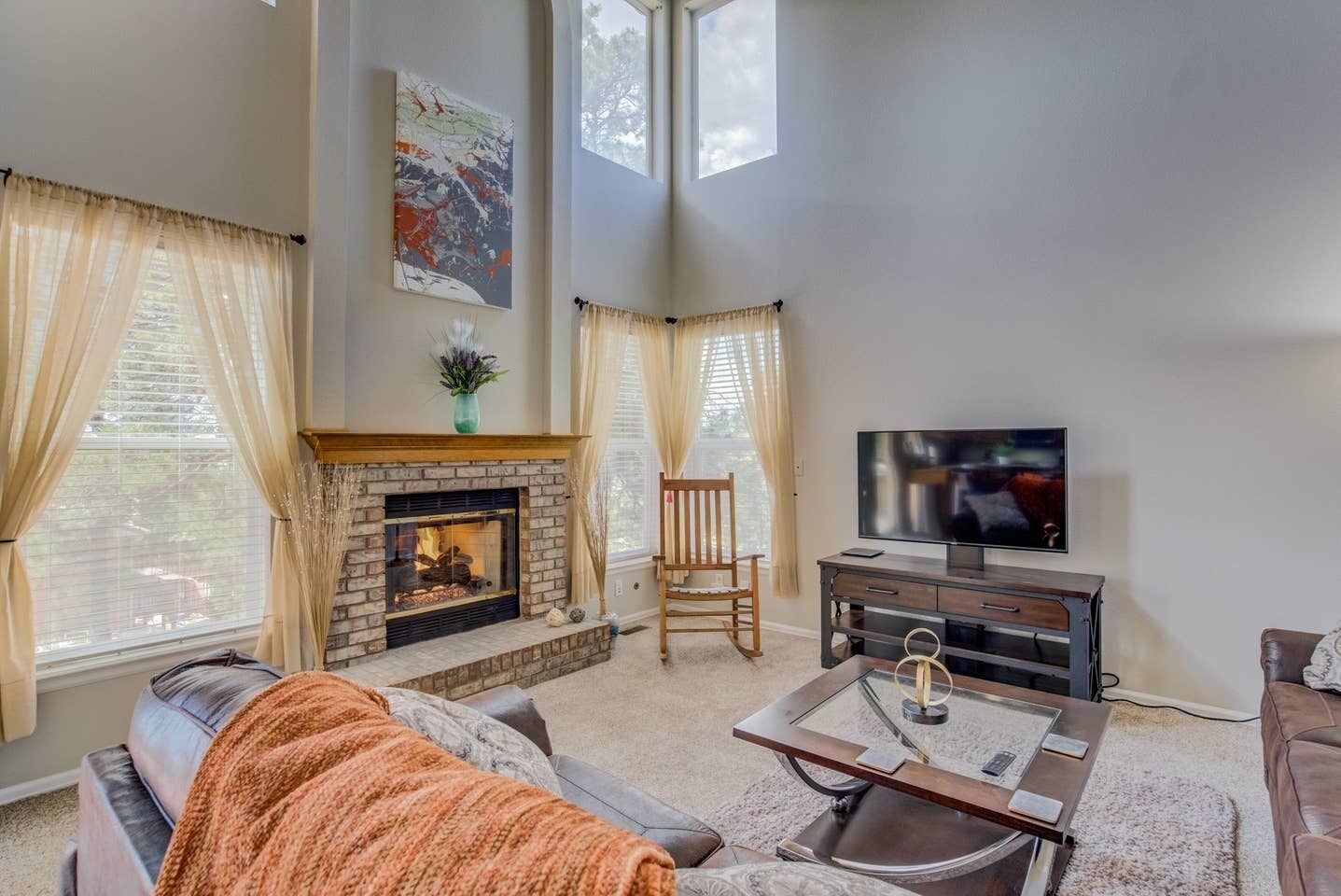 A living room with a fireplace, a television, and a comfortable seating area.