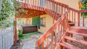 A wooden staircase leading to a hot tub area with a green wall and a white fence. - 4BR AF Academyw/hot Tub & Firepit (Colorado Springs)