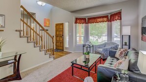 A spacious living room with a staircase, a sofa set, a coffee table, and a red carpet. - 4BR AF Academyw/hot Tub & Firepit (Colorado Springs)