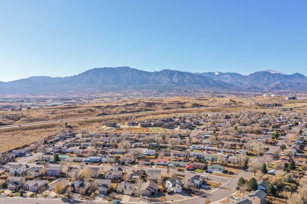 A residential area with houses and a mountain range in the background. - South Side COS & Ft. Carson Value Stay! Dogs OK! (Colorado Springs)