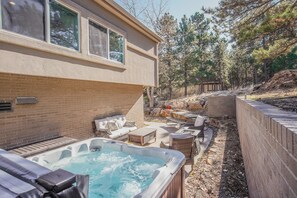 A backyard with a hot tub, outdoor seating, and a wooden deck. - Verdant Oasisluxury, Traveler's Home W/hottub! (Colorado Springs)