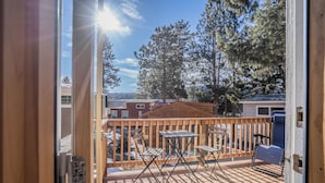 A deck with a view of a residential area, including houses and trees.