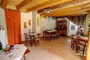 Un coin repas au style rustique, avec des meubles en bois, un sol carrelé et un plafond en bois.