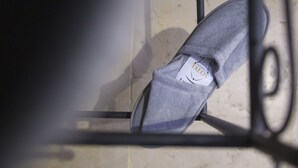 Un par de zapatos sobre una silla de metal con una etiqueta a la vista.