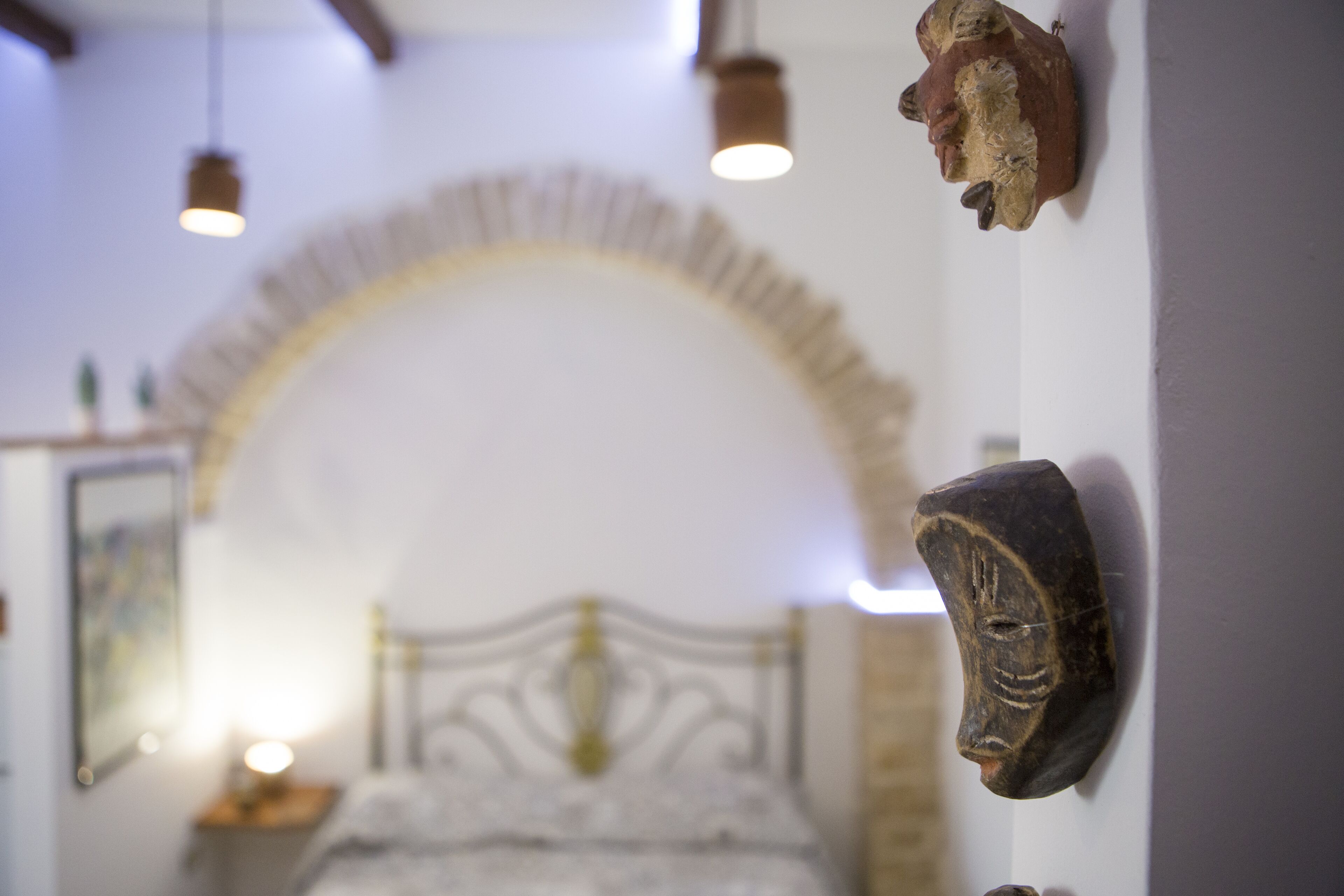 Ein Schlafzimmer mit einem Bett, einem Holz-Kopfteil und einem dekorativen Bogen darüber.