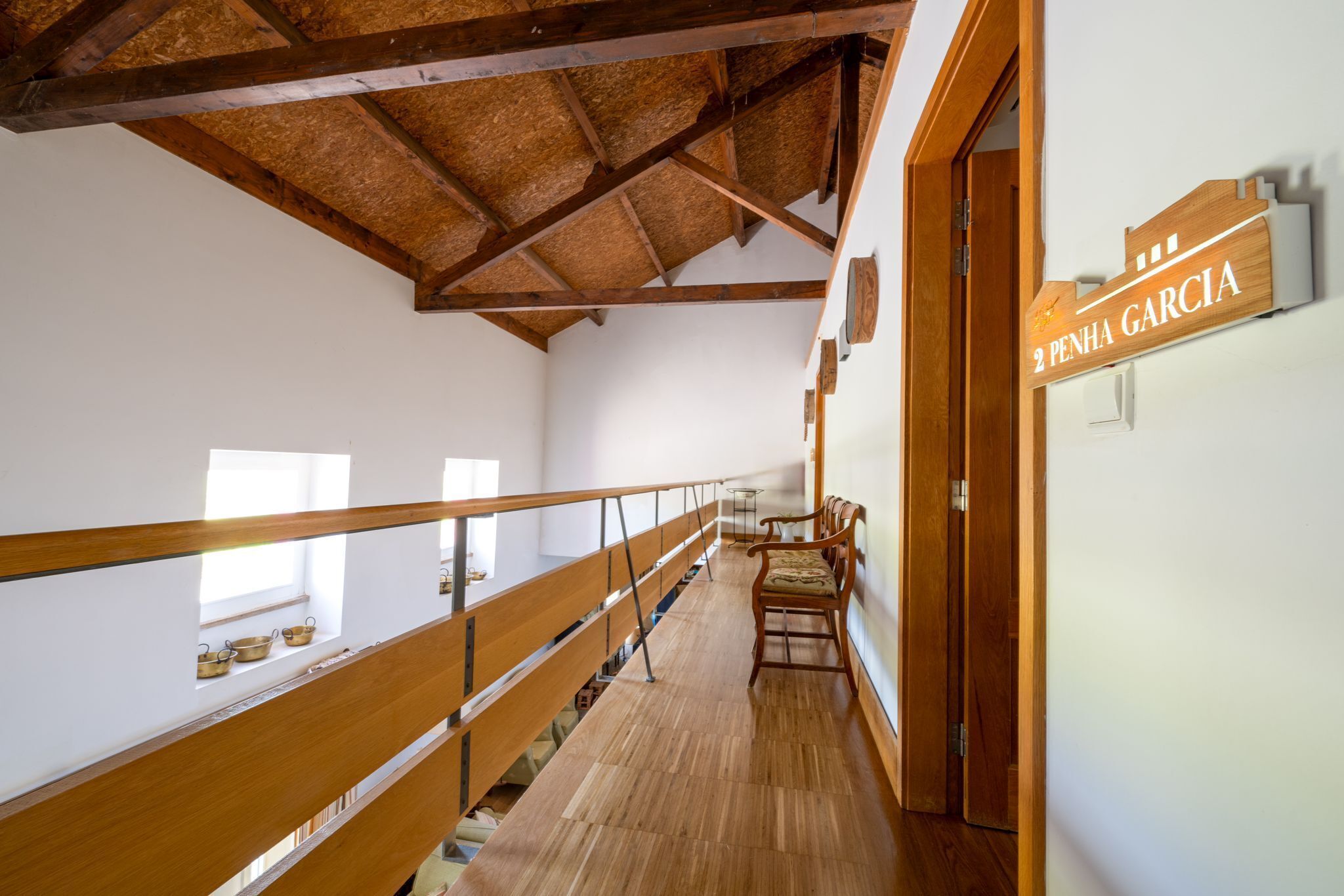L’intérieur est en bois, avec un plafond haut et une balustrade en bois. On peut voir une enseigne sur le mur où est inscrit « 2 Penha Garcia ».