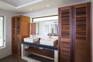 A bathroom with two sinks, wooden cabinets, and a large mirror.