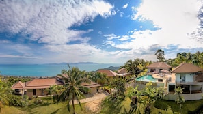 A resort with multiple bungalow-style buildings, a swimming pool, and a view of the ocean and distant mountains. - 1 Bedroom Sea View Villa Bubbles (Koh Samui)