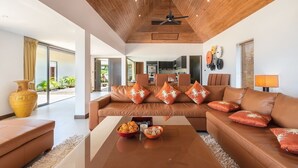 A modern living room with a brown leather sofa, a wooden ceiling, and a large window. - 2 Bedroom Sea View Villa Bubbles (Koh Samui)