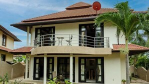A two-story building with a balcony, a satellite dish, and a palm tree in the foreground. - 4 Bedroom Villa TG39 on Beach Front Resort SDV285-By Samui Dream Villas  (Koh Samui)