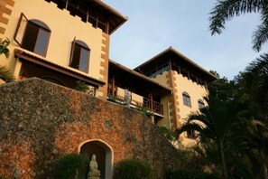 A building with a stone facade, multiple balconies, and a clear sky.