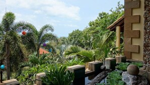 Um jardim exuberante com diversas plantas tropicais e um muro de pedra.