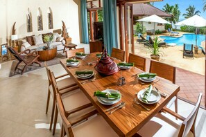 A dining area with a wooden table set for a meal, surrounded by chairs. - 5 Bedroom Beachfront Villa Sea Breeze SDV229A-By Samui Dream Villas (Koh Samui)