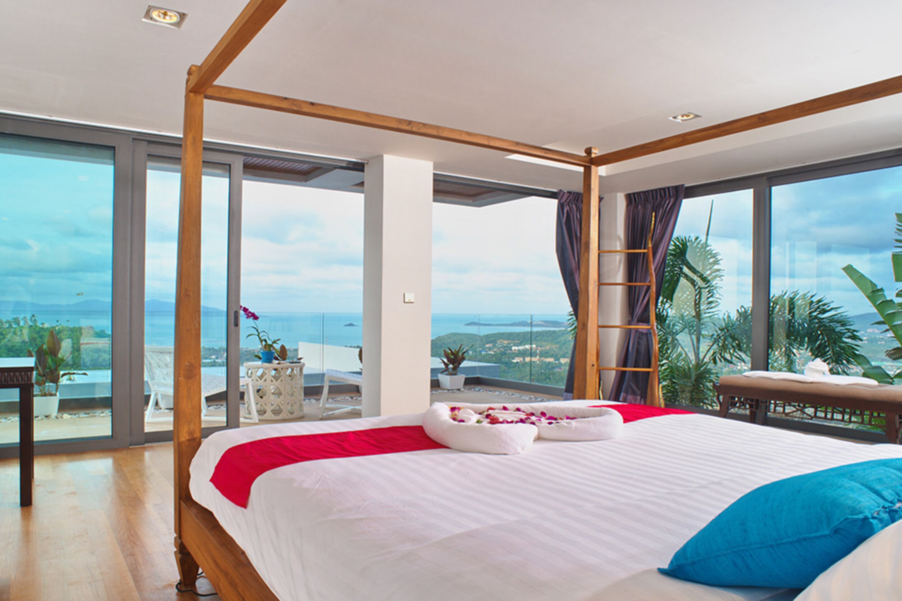 Un dormitorio amplio con una cama grande, un balcón con vistas y un techo de madera.