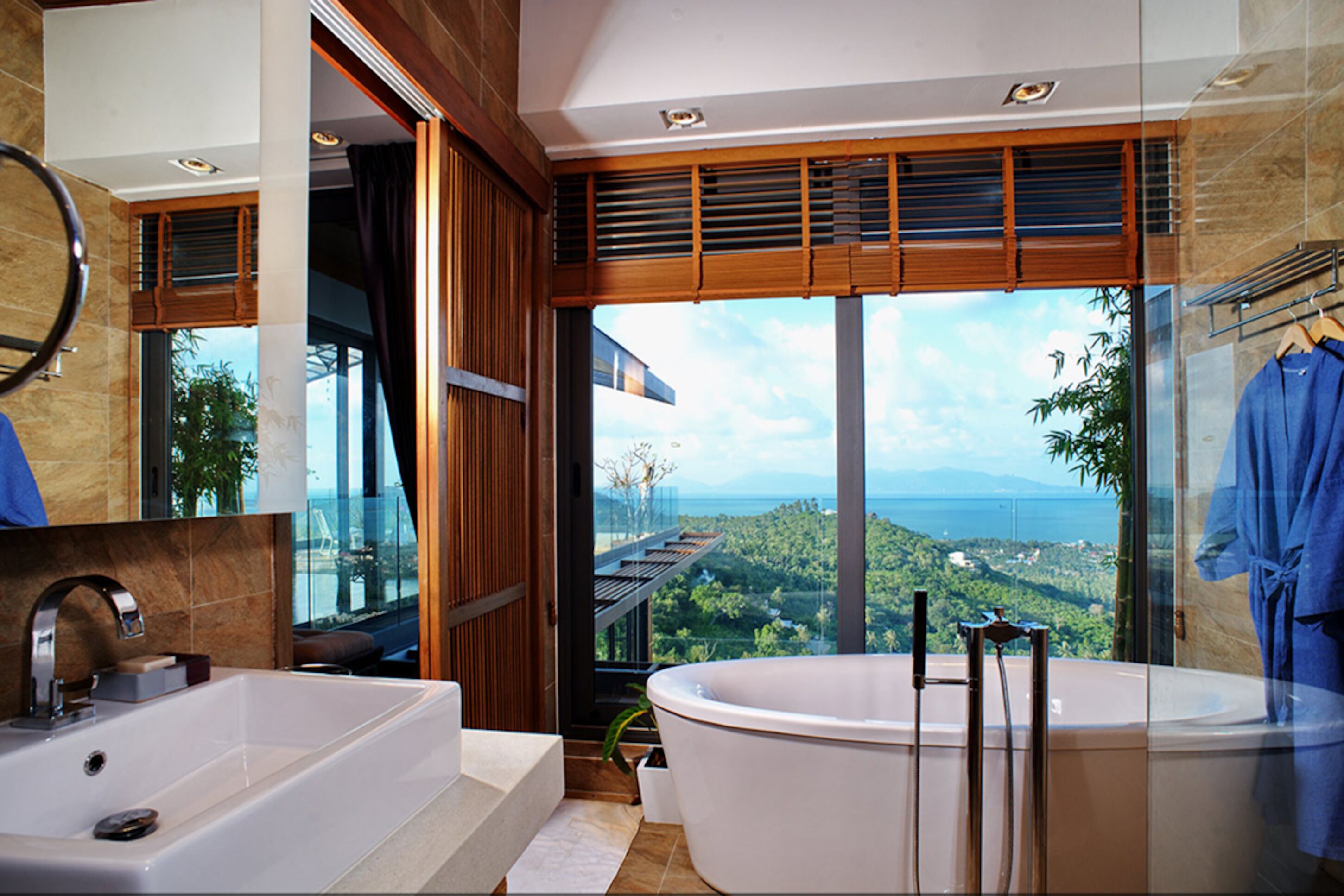A modern bathroom with a large bathtub, a separate sink, and a glass-enclosed shower area.