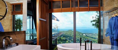 A modern bathroom with a large bathtub, a separate sink, and a glass-enclosed shower area.