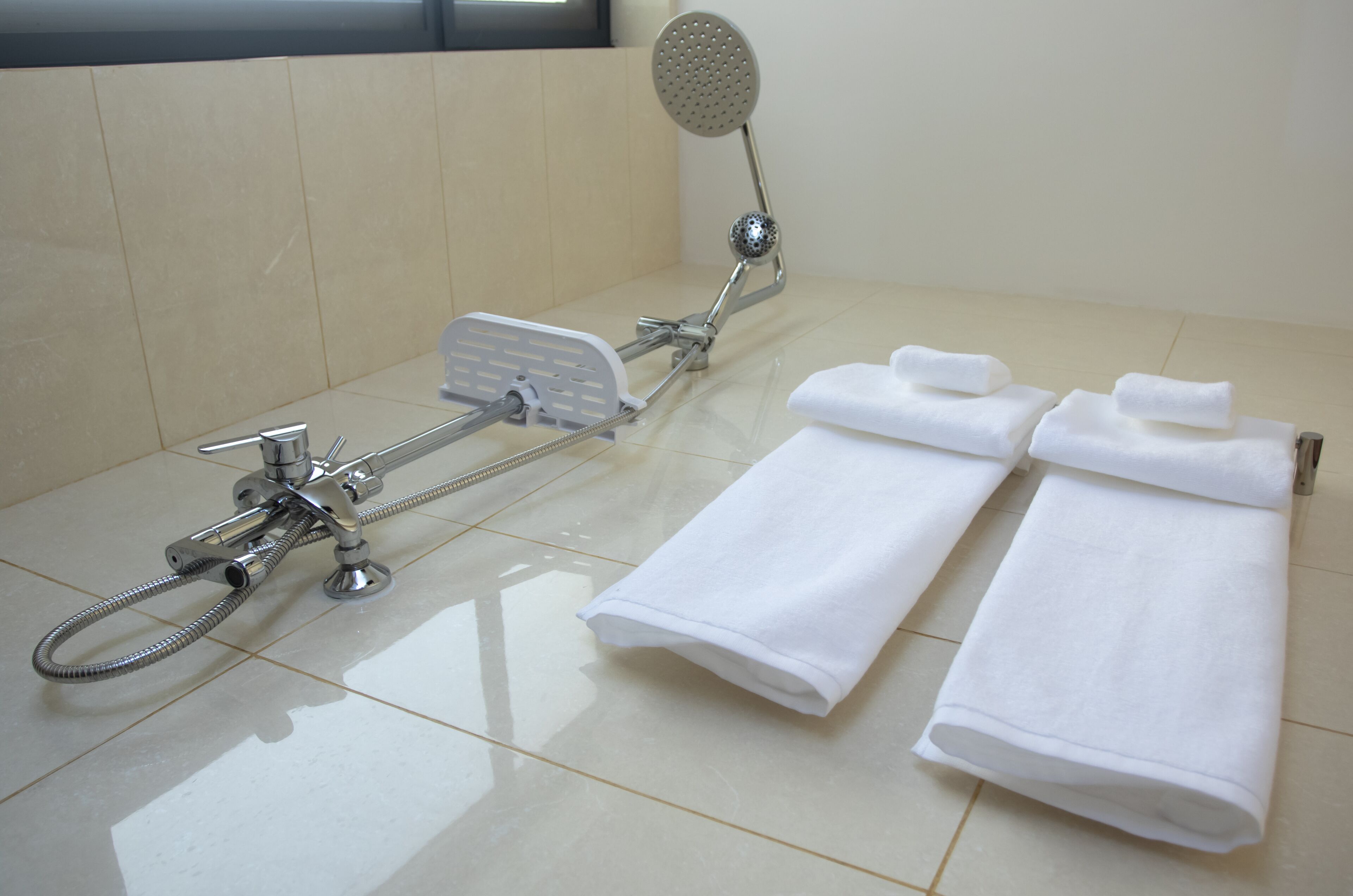 rainfall showerhead, hair dryer, slippers, towels