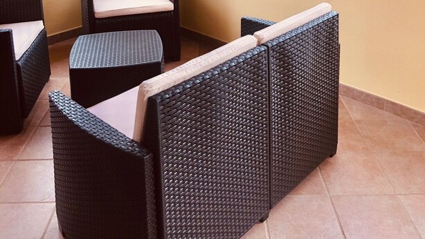 A balcony with wicker furniture and a view of a hilly landscape. - Fantastico San Teodoro STRAU02 (San Teodoro)