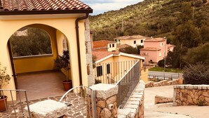 A building with a tiled roof, stone walls, and a paved courtyard. - Fantastico San Teodoro STRAU02 (San Teodoro)