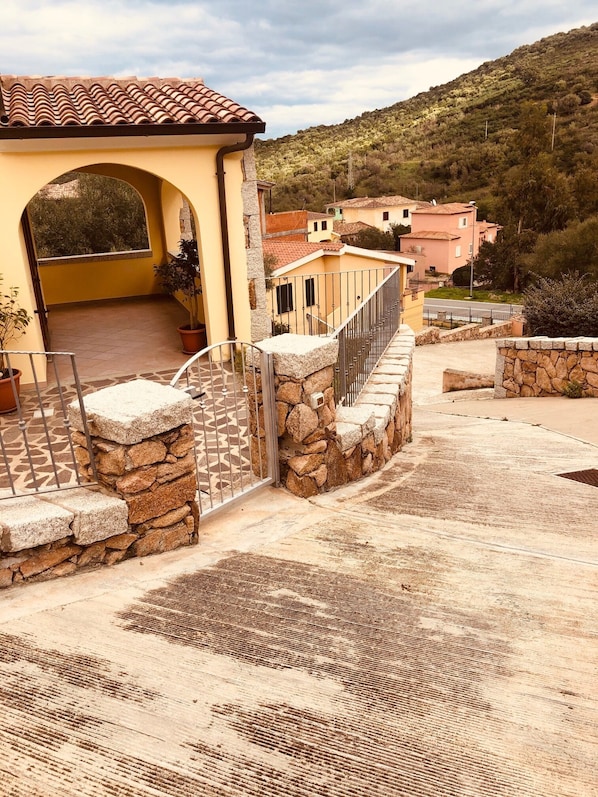 A building with a tiled roof, stone walls, and a paved courtyard.