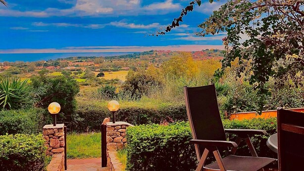 An outdoor patio with stone flooring, two chairs, and a table.