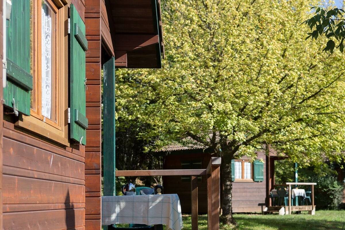A wooden building with a covered outdoor seating area.