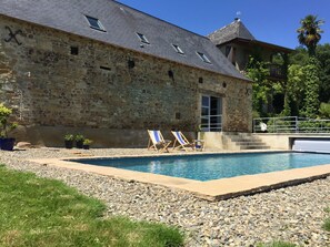 A stone building with a swimming pool, two lounge chairs, and a small staircase leading to a balcony. - B&B Maison D'Orride (Ledeuix)