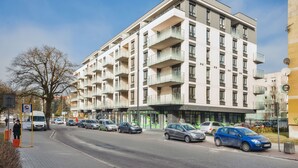 A multi-story hotel with balconies, a parking lot, and a clear sky. - Apartamenty Sun & Snow Na Solnej (Kolobrzeg)