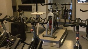 A gym with stationary bikes, a treadmill, and a mirror. - Carpe Diem (Charleroi)