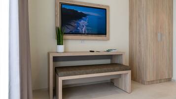 A modern living room with a flat-screen TV mounted on a wooden wall, a bench, and a cabinet.