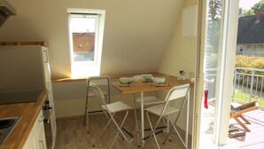 Une cuisine de taille réduite comprenant un coin repas, une fenêtre et une vue sur l’extérieur.