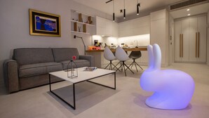 Ein modernes Wohnzimmer mit einer Couch, einem Couchtisch und einem einzigartigen beleuchteten Sessel.