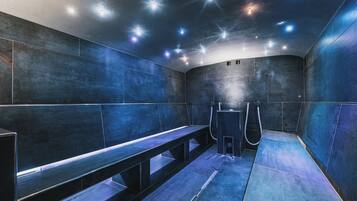 Relax in a serene sauna room with a curved bench and sleek tile design.