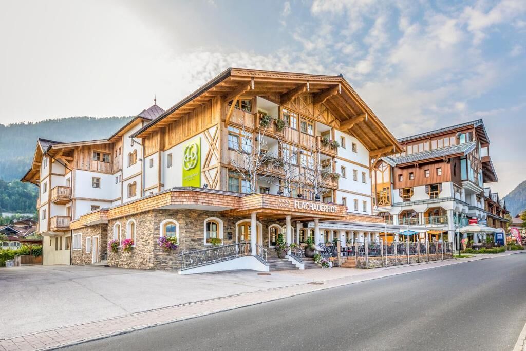 A multi-story hotel with a wooden facade, balconies, and a sign reading "FLACHAUERHOF".