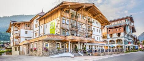 A multi-story hotel with a wooden facade, balconies, and a sign reading "FLACHAUERHOF".