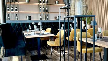 Un comedor moderno con piso de madera, una mesa central con sillas y una bodega en el fondo.
