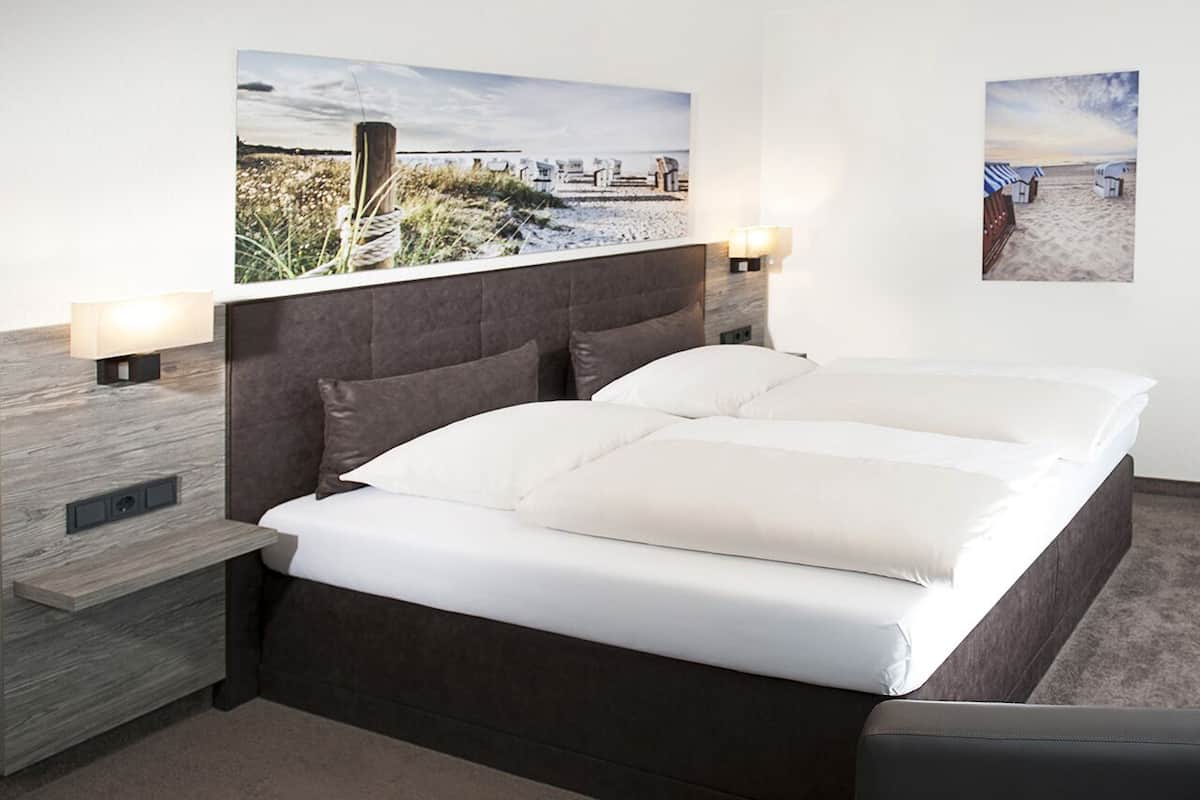 Ein modernes Schlafzimmer mit einem großen Bett, zwei Nachttischen und zwei Wandlampen.