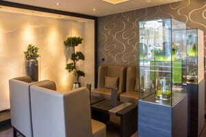 A modern lounge area with seating and a glass display case.
