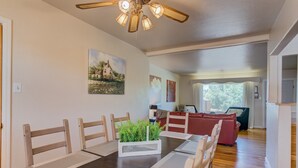Un coin repas avec une table en bois, des chaises et une plante décorative en guise de centre de table.