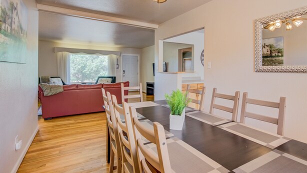 Un coin repas avec une table en bois foncé, des chaises de couleur beige et une plante en pot.