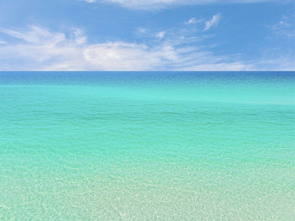 A clear view of a turquoise sea under a blue sky.