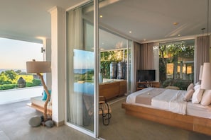 Ein modernes Schlafzimmer mit einem großen Bett, einem Fernseher und einer Glastür, die auf einen Balkon führt.