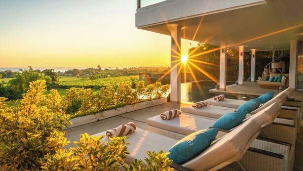 Un área de descanso exterior moderna con tumbonas y vistas al paisaje.